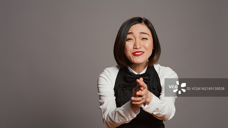 对着灰色背景微笑的年轻女人肖像图片素材