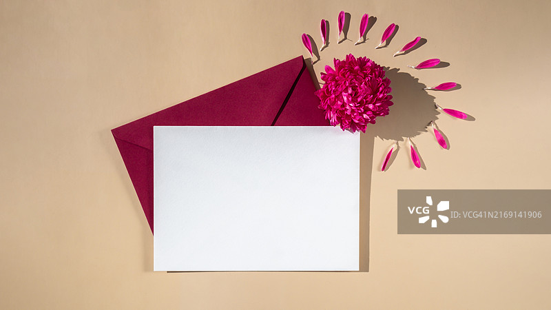 米色背景上的红色信封与粉色小花图片素材