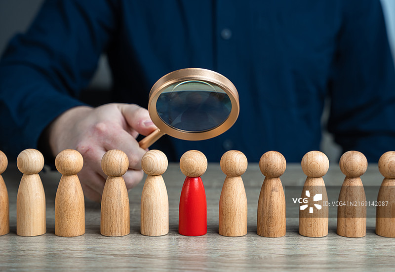 男子在木桌旁拿着放大镜的中段镜头图片素材