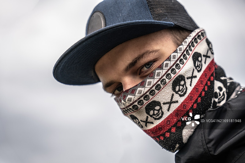 自信的年轻男子用头巾遮住脸，看向镜头的画像图片素材
