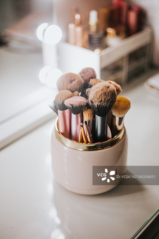 梳妆台上粉色容器中的化妆刷图片素材