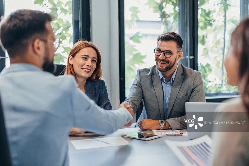 现代办公室中合作方握手的商务会议图片素材