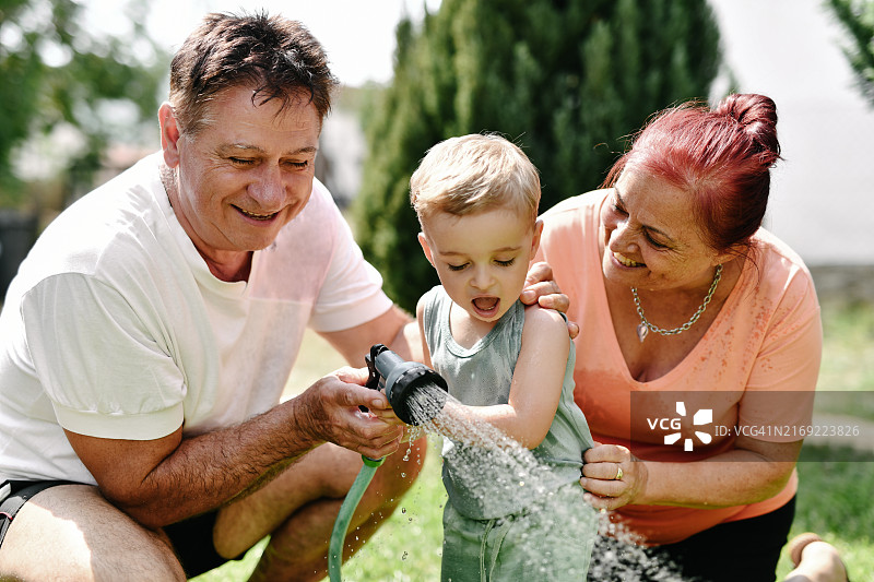 自豪的祖父母享受着教孙子使用喷嘴的时刻图片素材