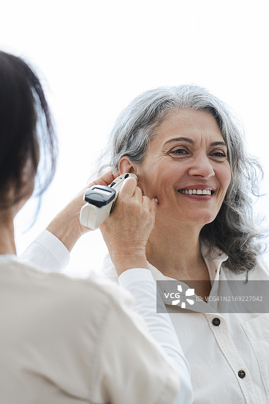 年长的医生在诊所里检查病人的耳朵图片素材