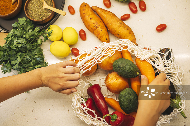 在纯素食准备过程中，在厨房台面上整理的新鲜蔬菜和水果以及香草和香料图片素材