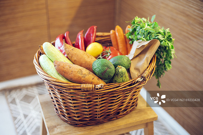明亮厨房木桌上的柳条篮果蔬图片素材