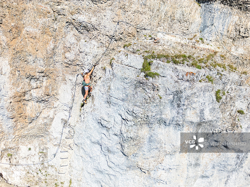 女人攀登山区陡峭岩壁图片素材