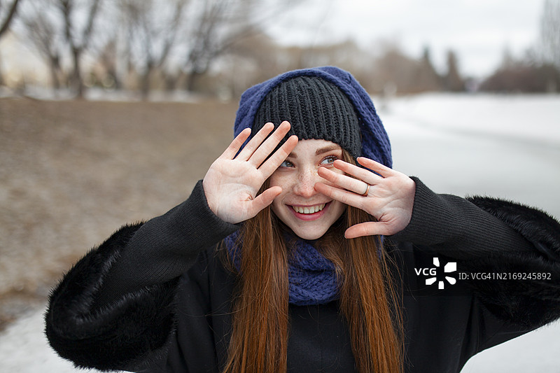 冬季微笑并做手势的红发女子图片素材