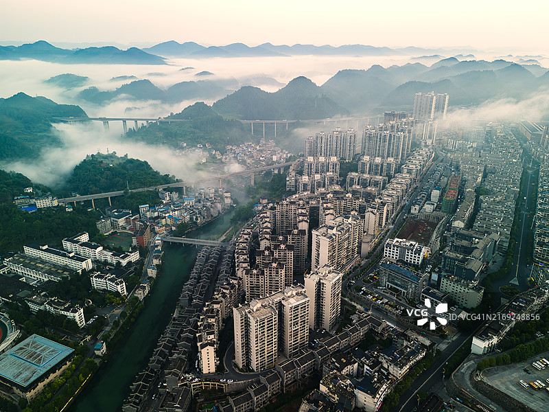 航拍视角：清晨古城河畔的长尾船与游客图片素材