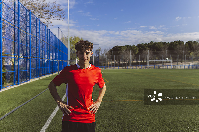 站在球场上的微笑足球运动员图片素材