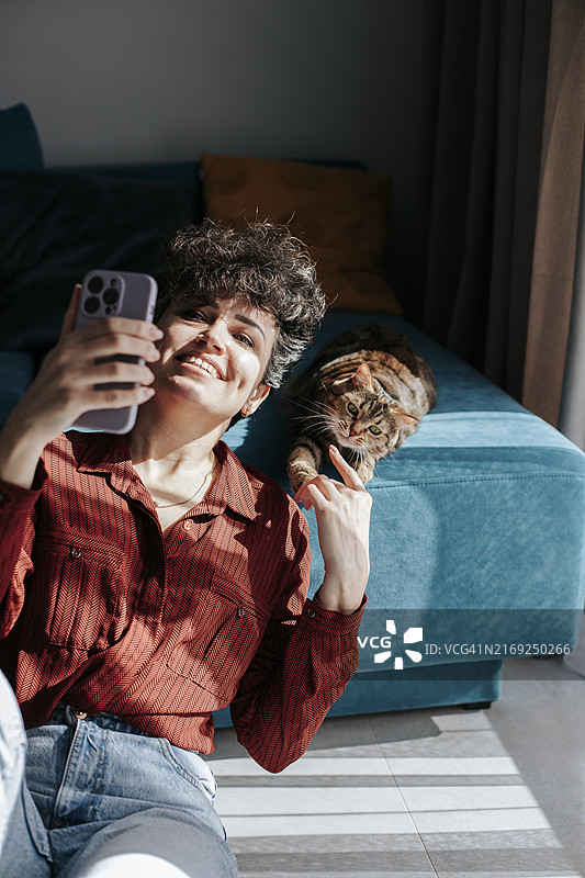 在家自拍并和猫玩耍的快乐女人图片素材