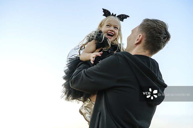 父亲背着女儿在蓝天下玩耍图片素材