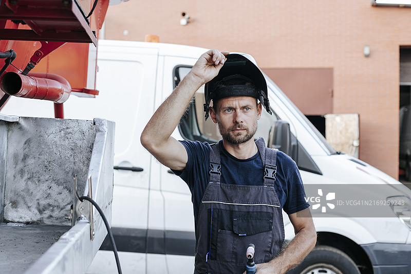 身穿防护服站在车库外的修理工图片素材