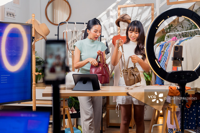 时尚的年轻亚洲电商女性，网红直播展示包包图片素材