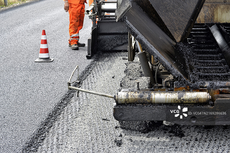 在道路上使用沥青机的工人图片素材
