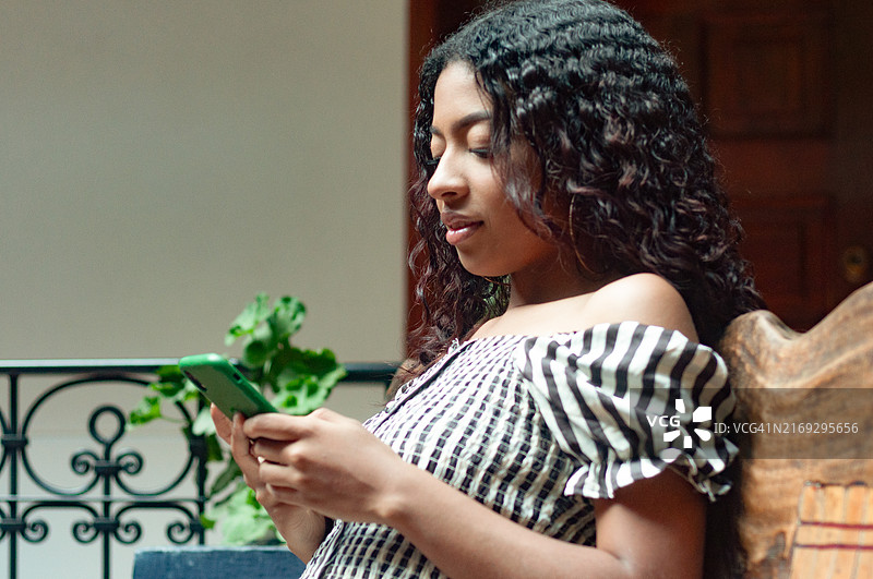 年轻拉丁裔女子正在使用智能手机图片素材