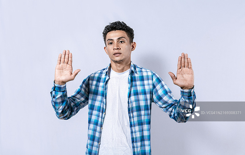 手掌抬起的，害怕和惊恐的男人。面带恐惧，双手抬起的男人。抬起双手的害怕的人的肖像，抬起双手的害怕的男人图片素材