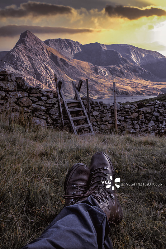 男子站在雪山下的田野里图片素材