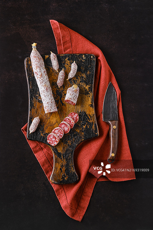 木制砧板上发酵的带有白色霉菌的萨拉米香肠顶视图图片素材