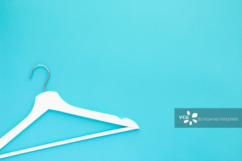 蓝色背景上的白色木制衣架图片素材