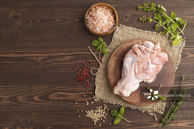 木制砧板上的生火鸡翅，配香草和香料图片素材