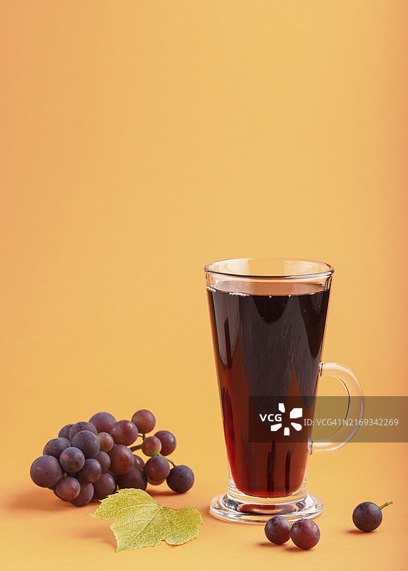 橙色背景下的红葡萄汁，健康饮品概念图片素材
