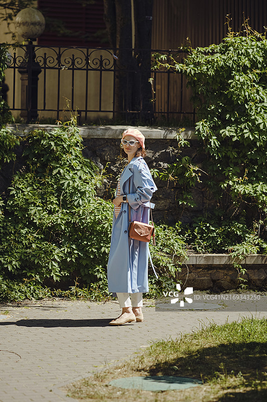 走在绿叶中的时尚潮流服装女人图片素材