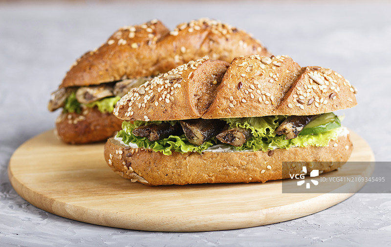 斯普拉特三明治配生菜和奶油奶酪，在灰色混凝土背景的木板上。侧视图，特写图片素材