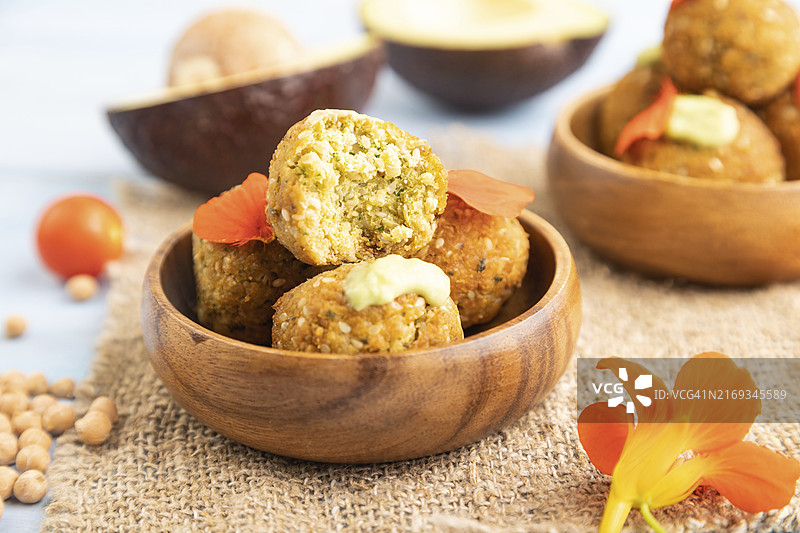 蓝色木质背景上搭配牛油果酱的炸豆丸子图片素材