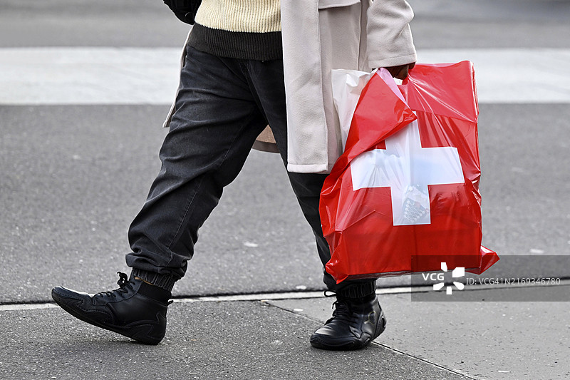 手提瑞士十字塑料袋的男人图片素材