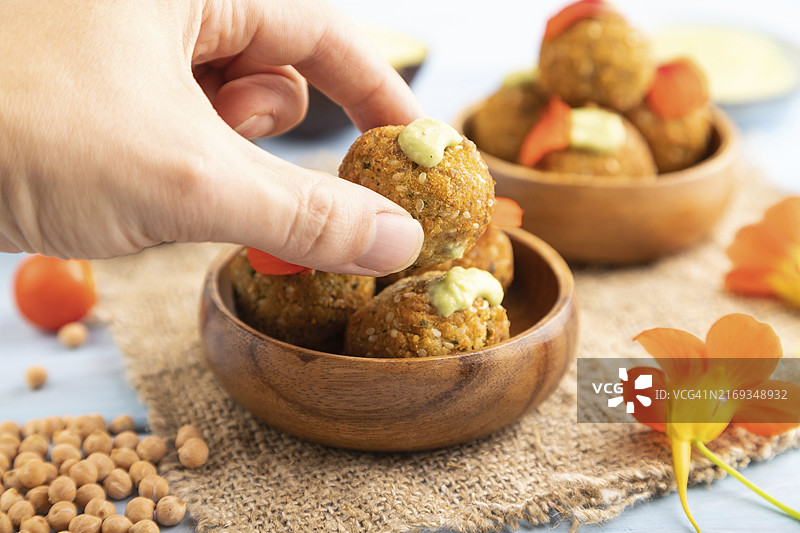 蓝木背景上手工亚麻布上的鳄梨酱炸豆丸图片素材