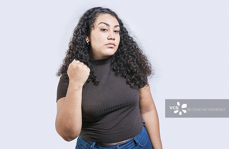 愤怒的女人挥舞着拳头进行威胁。不开心的女孩挥舞着拳头进行威胁。有攻击性的人的概念图片素材