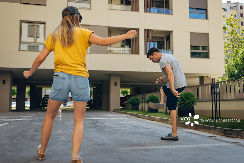 户外玩耍的两人：他们玩一种叫做毽子的游戏图片素材