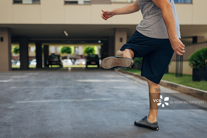 男人脚踢毽子保持平衡的特写图片素材