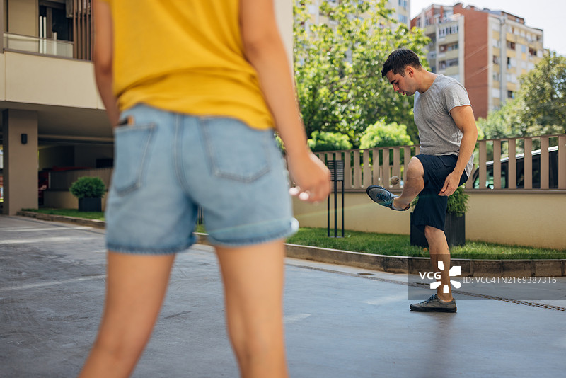 朋友们只用脚玩一种叫毽球的游戏，他们必须尽可能长时间地不让毽子落地图片素材