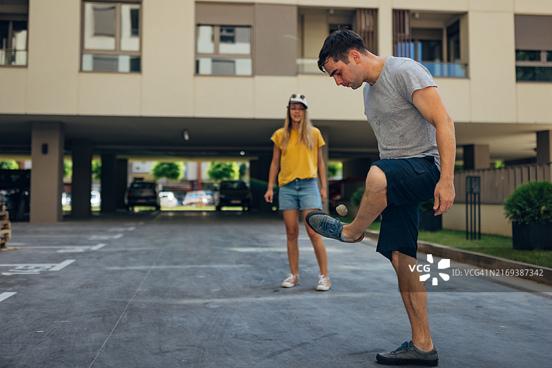 两个好朋友只用脚玩踢毽子游戏图片素材
