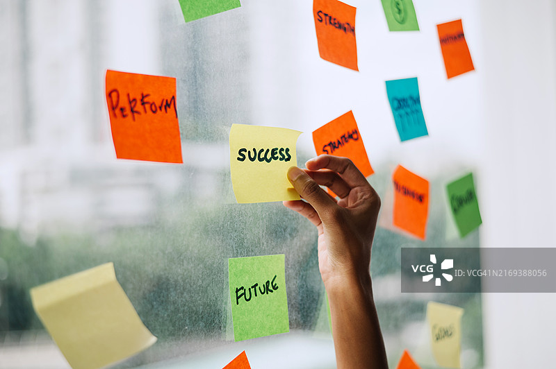 女商人手持便签在办公室窗口的特写图片素材