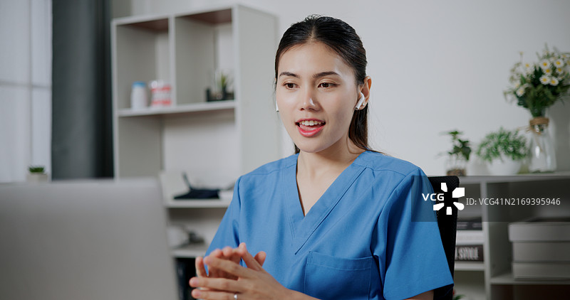 医疗专业人员视频通话，了解办公室笔记本电脑上的医学教科书，患者治疗计划图片素材