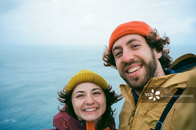 在冰岛多风海滩上用胶片相机拍摄的男女自拍图片素材