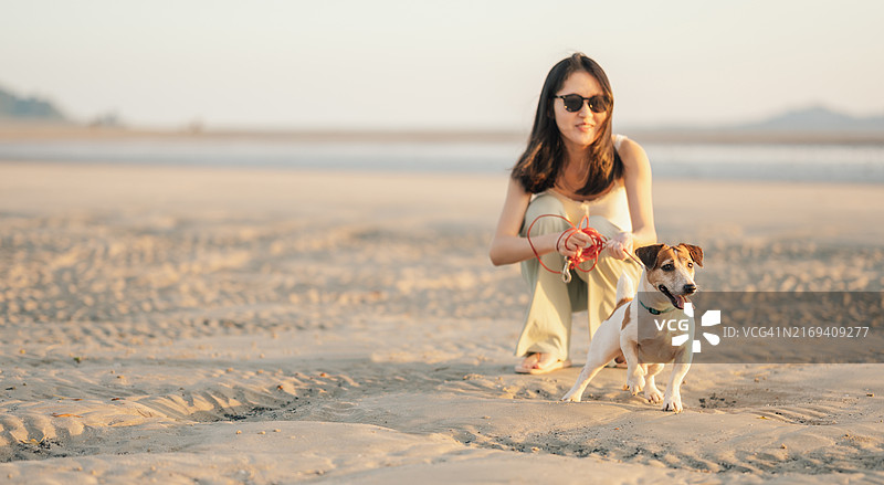 Z世代和毛茸茸的朋友杰克罗素梗犬在海滩散步图片素材