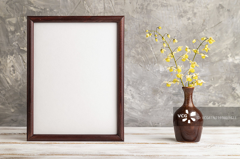 木制框架与陶瓷花瓶中的黄色淫羊藿花，灰色背景图片素材
