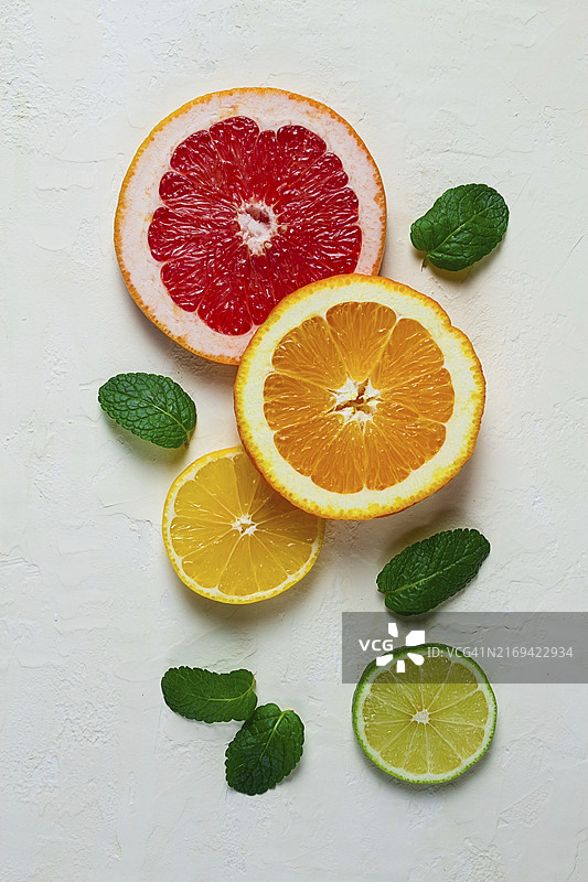 食物概念壁纸：浅色桌面上切片的柑橘水果与薄荷叶俯视图食物背景图片素材