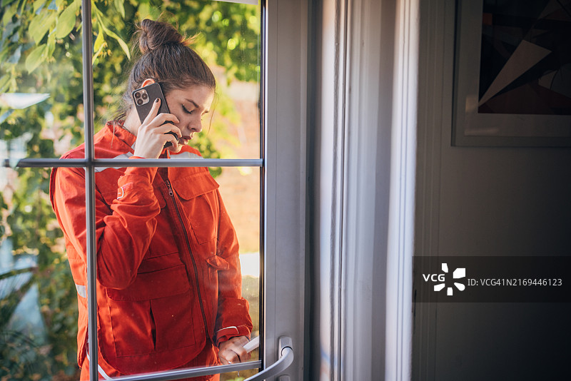 玻璃门旁正在通话的救援人员图片素材
