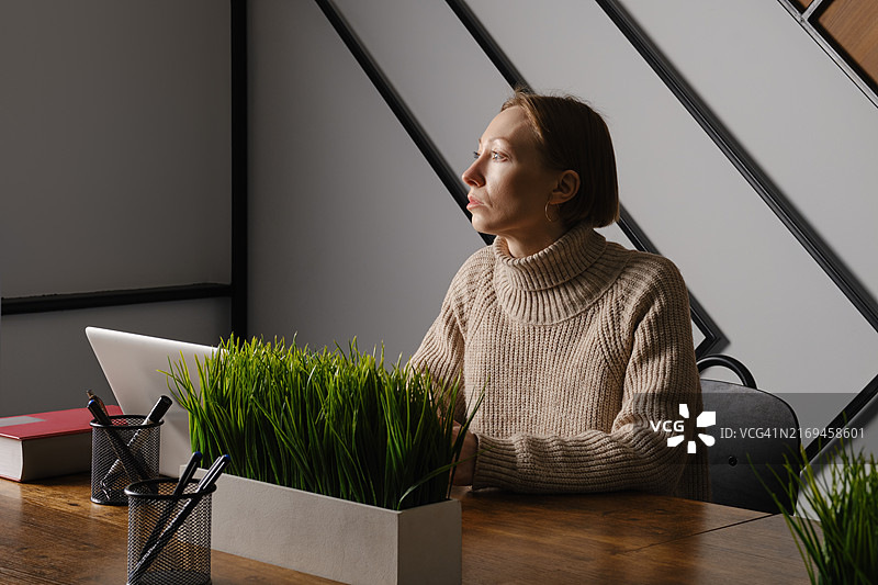 深夜在办公室加班的中年妇女图片素材