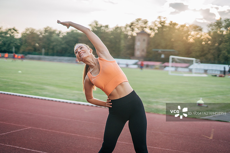 年轻女人在户外跑道上锻炼图片素材