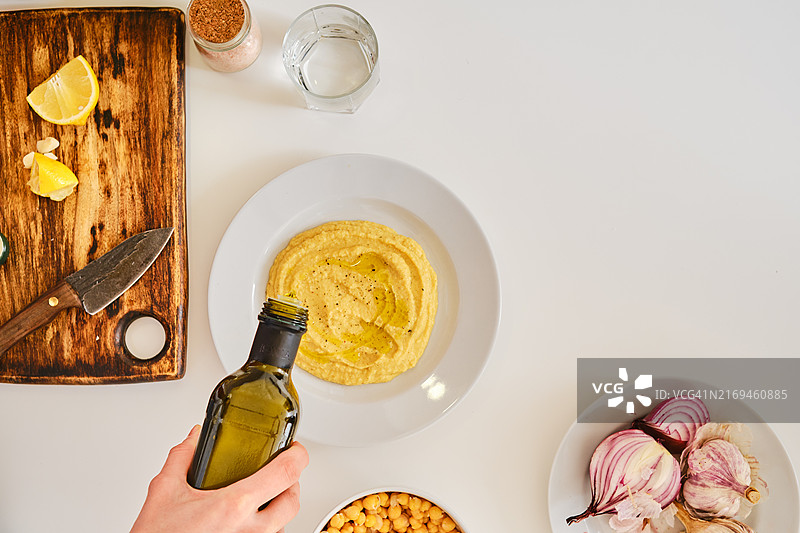 在鹰嘴豆泥中加入橄榄油（俯视图）图片素材