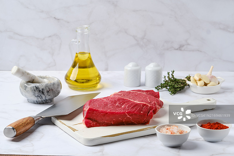 厨房桌子上带有香料和香草的生鲜上脑牛排图片素材