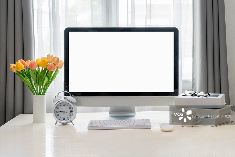 时尚的工作区正面图，带有样机电脑和办公用品小工具。用于图形显示蒙太奇的空白屏幕。简约办公室内的空白屏幕台式电脑，带有装饰和复制空间图片素材