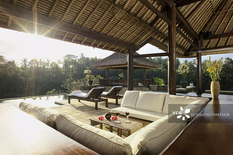 巴厘岛风格度假村休息区，设有无边泳池图片素材