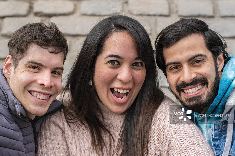 三个微笑的朋友看着镜头图片素材